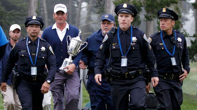 Webb Simpson doprovázen policejní eskortou s pohárem pro vítěze golfového US Open