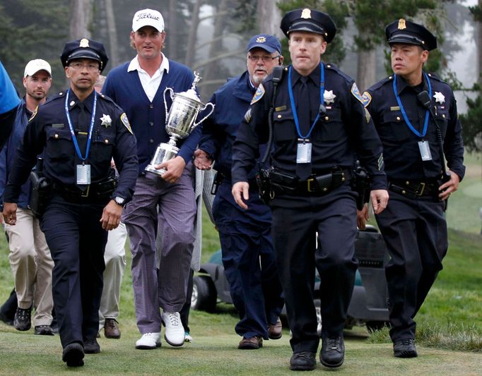 Webb Simpson doprovázen policejní eskortou s pohárem pro vítěze golfového US Open