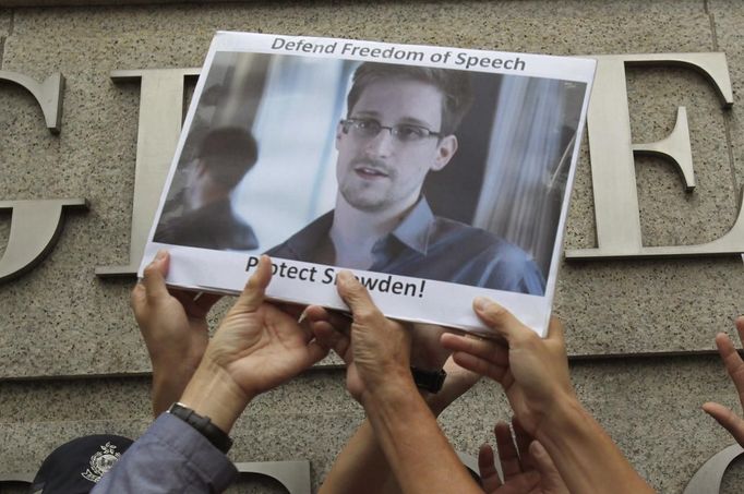 Protesters in support of Edward Snowden, a contractor at the National Security Agency (NSA), hold a photo of him during a demonstration outside the U.S. Consulate in Hong