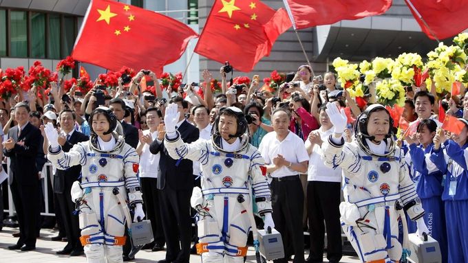Chinese astronauts Jing Haipeng, Liu Wang (C) and Liu Yang (L), China's first female astronaut, wave during a departure ceremony at Jiuquan Satellite Launch Center, Gansu province, June 16, 2012. China will send its first woman into outer space this week, prompting a surge of national pride as the rising power takes its latest step towards putting a space station in orbit within the decade. Liu Yang, a 33-year-old fighter pilot, will join two other astronauts aboard the Shenzhou 9 spacecraft when it lifts off from a remote Gobi Desert launch site on Saturday evening. REUTERS/Jason Lee (CHINA - Tags: SCIENCE TECHNOLOGY) Published: Čer. 16, 2012, 8:13 dop.