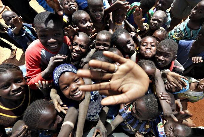 Children wave to media in the the recently liberated town of Konna January 26, 2013. REUTERS/Eric Gaillard (MALI - Tags: CIVIL UNREST CONFLICT MILITARY) Published: Led. 26, 2013, 2:59 odp.