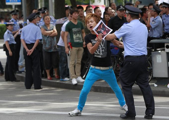 A police officer try to stop a protester during a demonstration outside the Japanese consulate in Shanghai September 15, 2012. Thousands of protesters besieged the Japanese embassy in Beijing on Saturday, hurling rocks and bottles at the building as police struggled to keep control, amid growing tensions between Asia's two biggest economies over a group of disputed islands. REUTERS/Aly Song (CHINA - Tags: POLITICS)