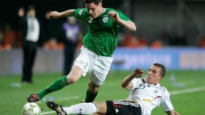 Irský reprezentant Steve Finnan v souboji s Němcem Lukasem Podolskim v kvalifikačním utkání skupiny D v Dublinu.