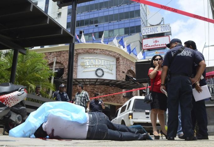 ATTENTION EDITORS - VISUAL COVERAGE OF SCENES OF INJURY OR DEATH Federal policemen stand next to the body of a man in Acapulco August 17, 2012. Unknown assailants gunned down the victim, who was a lawyer, while he was walking in the major tourist area of La Costera, local media reported. Picture taken August 17, 2012. REUTERS/Violeta Schmidt (MEXICO - Tags: CIVIL UNREST CRIME LAW) TEMPLATE OUT Published: Srp. 18, 2012, 2:27 odp.