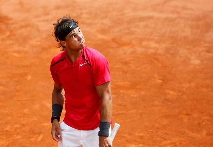 Španělský tenista Rafael Nadal sleduje nebe, ze kterého začalo pršet a utkání s Davidem Ferrerem muselo být přerušeno během semifinále French Open 2012.