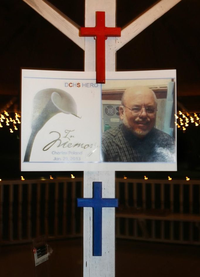 A sign and crosses honoring the memory of bus driver Charles Poland is erected during a candlelight vigil at City Hall in Midland City, Alabama, January 31, 2013. The vigil honored the memory of bus driver Poland, and showed support for the release of a five-year-old boy held hostage in a bunker by Poland's alleged killer. REUTERS/Phil Sears (UNITED STATES - Tags: CRIME LAW) Published: Úno. 1, 2013, 2:32 dop.