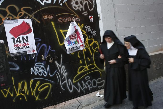 Two Catholic nuns walks past banners that read "14N, general strike" (L) and "14N. We stop everything!!" in central Madrid November 12, 2012. Spain's two largest labour unions had called a general strike for November 14, the second against the conservative government since they took power in December and coinciding with industrial action in Portugal on the same day. REUTERS/Susana Vera (SPAIN - Tags: SOCIETY BUSINESS RELIGION EMPLOYMENT) Published: Lis. 12, 2012, 6:19 odp.