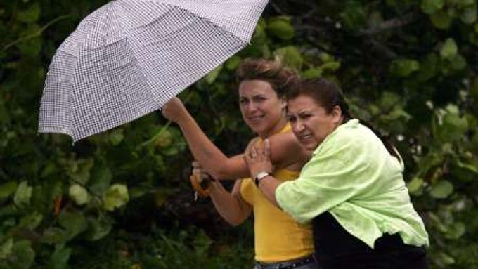 Ženy bojují s větrem, který na americké pobřeží přinesla bouře Ernesto.