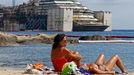 People sunbathe as the Costa Concordia cruise liner is seen during its refloating operation at Giglio harbour July 21, 2014.