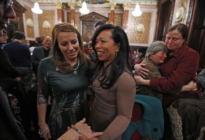 Mercedes Santos (2nd L) and partner Theresa Volpe (L) are congratulated on the results of a vote by the Senate Executive Committee on same-sex marriages as their friends Becky Crawford (2nd R) and Peggy Cloonan celebrate at the Illinois State Legislature in Springfield, Illinois, January 3, 2013. The Commitee voted 8-5 to send the bill to a full vote in the Senate. Picture taken January 3, 2013. REUTERS/Jim Young (UNITED STATES - Tags: SOCIETY) Published: Bře. 25, 2013, 6:07 odp.