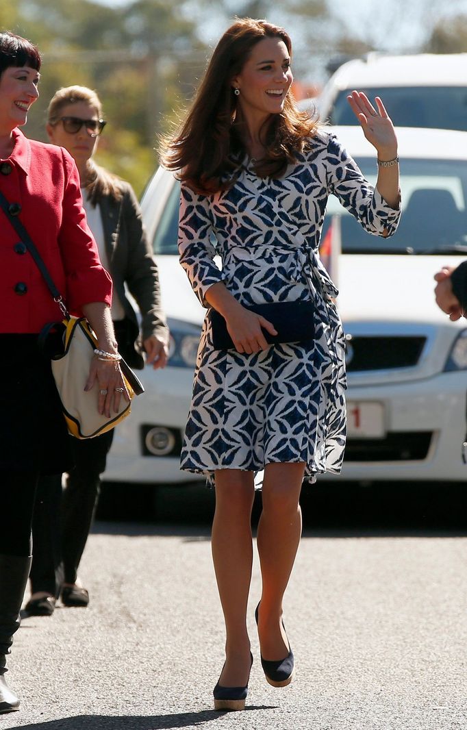 Catherine, Duchess of Cambridge, waves as she walks down a road in the Blue Mountains suburb of Winmalee, that lost homes during bushfires last year