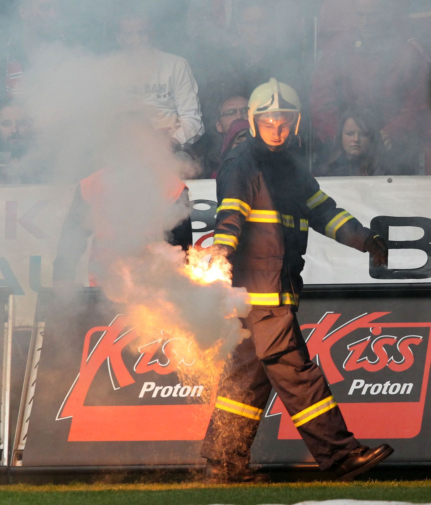 Hasiči odnášejí dýmovnici v utkání Plzně se Spartou Praha v sedmém kole Gambrinus ligy 2012/13.