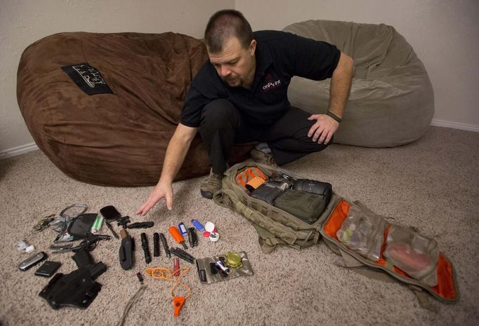 Phil Burns inventories some of the gear in a backpack full of survival supplies at his home in American Fork, Utah, December 14, 2012. While most "preppers" discount the Mayan calendar prophecy, many are preparing to be self-sufficient for threats like nuclear war, natural disaster, famine and economic collapse. Picture taken December 14, 2012. REUTERS/Jim Urquhart (UNITED STATES - Tags: SOCIETY) Published: Pro. 18, 2012, 5:23 odp.