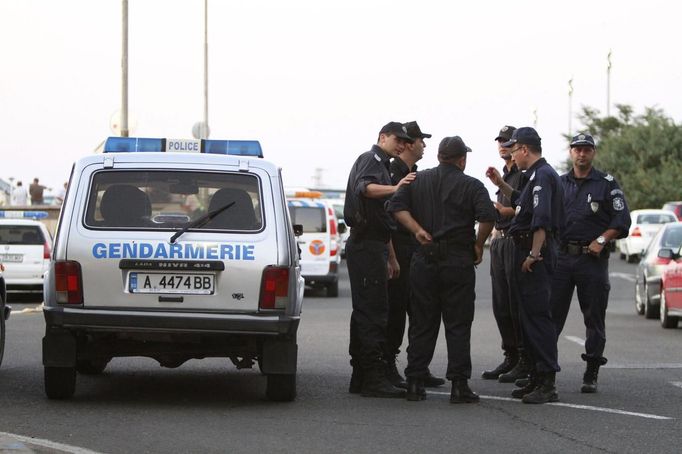 Police officers stand near a police vehicle after an explosion at Bulgaria's Burgas airport July 18, 2012. An explosion which killed six people and injured dozens of Israeli tourists at the Bulgarian airport of Burgas was caused by a bomb in their bus, Bulgarian Foreign Minister Nikolai Mladenov told Reuters by telephone. In a statement, the foreign ministry said five people were killed and one died later in hospital. Thirty two people were taken to hospital with injuries. REUTERS/Impact Press Group (BULGARIA - Tags: DISASTER TRANSPORT CRIME LAW)