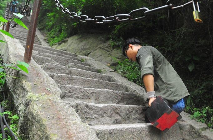 HUAYIN, CHINA - AUGUST 13: (CHINA OUT) Legless man Chen Zhou climbs the Huashan Mountain on August 13, 2012 in Huayin, Shaanxi Province of China. Legless 29-year-old man Chen Zhou from Cangshan of Shandong Province spent two days, 19 hours in total, climbing by arms to the top of Huashan Mountain. Chen lost his legs after falling off a train at the age of 13, but he has since strived to be stronger and joined in many public performances to encourage other people. Chen Zhou will climb the Taishan Mountain in Shandong province in the following months. ( automatický překlad do češtiny )