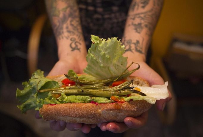 May Wollf, 28, a practising 'freegan', holds a sandwich that is made entirely out of found or donated food in Vancouver, British Columbia April 11, 2012. A 'freegan' is someone who gathers edible food from the garbage bins of grocery stores or food stands that would otherwise have been thrown away. Freegans aim to spend little or no money purchasing food and other goods, not through financial need but to try to address issues of over-consumption and excess. Picture taken April 11, 2012. REUTERS/Ben Nelms (CANADA - Tags: SOCIETY) ATTENTION EDITORS PICTURE 11 OF 21 FOR PACKAGE 'DUMPSTER DIVING FOR FOOD' Published: Kvě. 15, 2012, 11:58 dop.