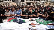 Palestinci se modlí nad těly novinářů, včetně Anase al‑Šarífa a Muhammada Kríky, zabitých při izraelském náletu, během pohřbu před nemocnicí Šífa v Gaze.