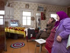 Muž a žena sledují ve svém domku ve východoběloruské vesnici televizní projev Alexandra Lukašenka.