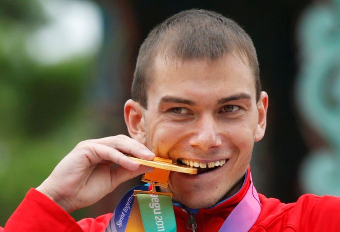 FILE PHOTO: Sergey Bakulin of Russia bites his gold medal after the men's 50 km race walk final at the IAAF World Athletics Championships in Daegu September 3, 2011.