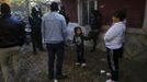 Five-year-old Moises Echevarria (C) looks at his family as Spanish riot police prevent them from approaching a bulldozer that is demolishing their living-room at the Spanish gypsy settlement of Puerta de Hierro outside Madrid November 8, 2011. Fifty-four families have been living in Puerta de Hierro, on the banks of the Manzanares river for over 50 years. Since the summer of 2010, the community has been subject to evictions on the grounds that the dwellings are illegal. Families whose houses have been demolished, move in with relatives whose houses still remain while the debris keeps piling up around them as more demolitions take place. Picture taken November 8, 2011. REUTERS/Susana Vera (SPAIN - Tags: SOCIETY) ATTENTION EDITORS - PICTURE 15 OF 31 FOR PACKAGE 'GYPSY SITE DEMOLISHED' SEARCH 'GYPSY SITE' FOR ALL IMAGES Published: Lis. 5, 2012, 4:11 odp.