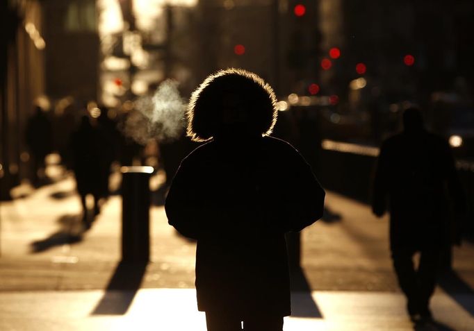 A commuter wearing a fur-lined hood walks down West 42nd Street as the sun rises in New York City January 24, 2013. REUTERS/Mike Segar (UNITED STATES - Tags: ENVIRONMENT SOCIETY) Published: Led. 24, 2013, 1:42 odp.