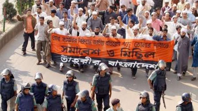 Policisté doprovázejí muslimy, kteří včera v Dhace protestovali proti sérii bombových útoků extremistů. Poslední sebevražedný útočník ve městě Netrakona zabil sebe a 7 lidí, 50 dalších zranil.
