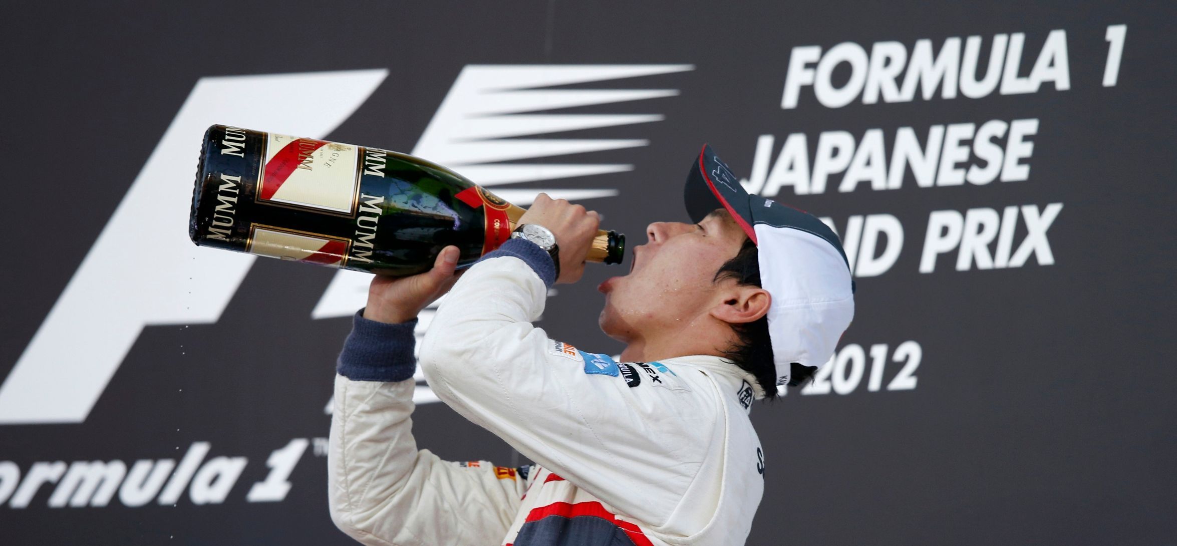 Kamui Kobajaši si vychutnává šampaňské na pódiu po VC Japonska