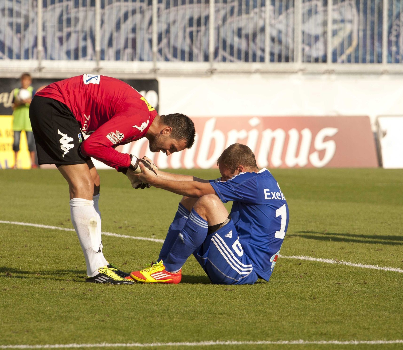 Fotbalový brankář Slovácka Dušan Melichárek pomáhá olomouckému Michalu Hubníkovi v utkání 2. kola Gambrinus ligy.