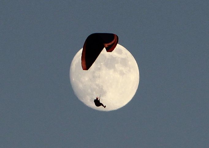 Paraglidista míjí Měsíc nad vrcholky kalifornských kopců Tehachapi.