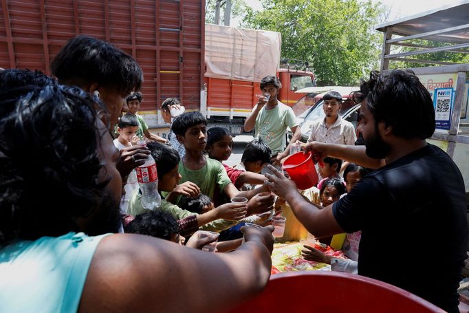 Místní obyvatelé nabízejí lidem chlazené nápoje, Nové Dillí, Indie, 29. května 2024.