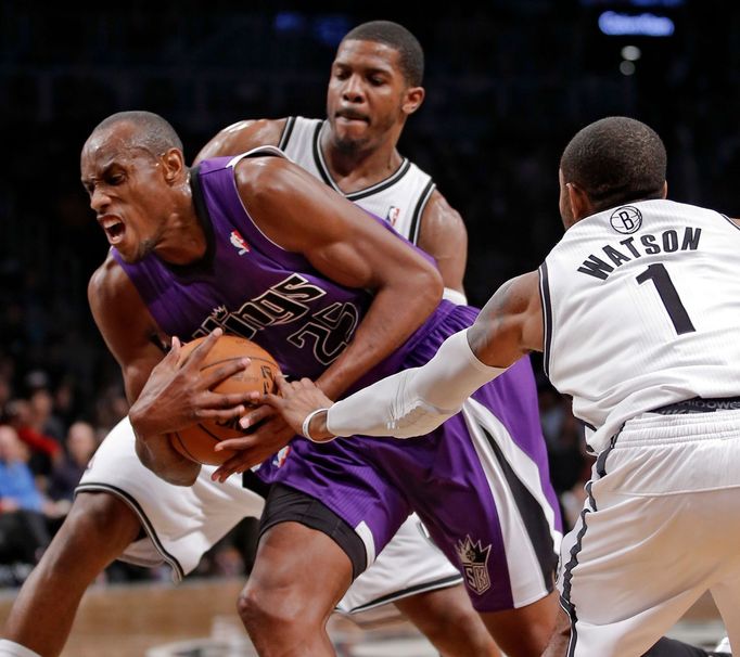 Basketbalista Sacramenta King Travis Outlaw se snaží probít mezi bránícími hráči Brooklyn Nets