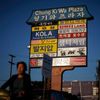 Woman cycles past a mall sign in Korean in the Koreatown area of Los Angeles