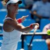 Mandy Minella of Luxembourg hits a return to Carina Witthoeft of Germany during their women's singles match at the Australian Open 2014 tennis tournament in Melbourne