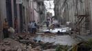 People walk near to a damaged building in Santiago de Cuba October 25, 2012. Hurricane Sandy grew into a major potential threat to the east coast of the United States on Thursday after hammering Cuba's second-largest city and taking aim at the Bahamas, U.S. forecasters said. Strengthening rapidly after tearing into Jamaica and crossing the warm Caribbean Sea, Sandy hit southeastern Cuba early on Thursday with 105-mph winds that cut power and blew over trees across the city of Santiago de Cuba. Reports from the city of 500,000 people, about 470 miles (750 km) southeast of Havana spoke of significant damage, with many homes damaged or destroyed. According to one Cuban radio report, at least one person was killed, bringing the death toll to at least three after fatalities in Jamaica and Haiti. REUTERS/Miguel Rubiera/Cuban Government National Information Agency - AIN/Handout (CUBA - Tags: ENVIRONMENT DISASTER) FOR EDITORIAL USE ONLY. NOT FOR SALE FOR MARKETING OR ADVERTISING CAMPAIGNS. THIS IMAGE HAS BEEN SUPPLIED BY A THIRD PARTY. IT IS DISTRIBUTED, EXACTLY AS RECEIVED BY REUTERS, AS A SERVICE TO CLIENTS Published: Říj. 25, 2012, 5:47 odp.