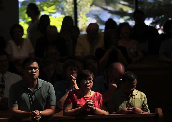 People pray during a morning mass remembering the victims of the movie theatre shootings, at the Queen of Peace Catholic Church in Aurora, Colorado July 22, 2012. President Barack Obama travels to Colorado on Sunday to meet families bereaved after a "demonic" gunman went on a shooting rampage at a movie theater in a Denver suburb, killing at least 12 people and wounding 58. REUTERS/Shannon Stapleton (UNITED STATES - Tags: DISASTER SOCIETY CIVIL UNREST RELIGION) Published: Čec. 22, 2012, 5:14 odp.