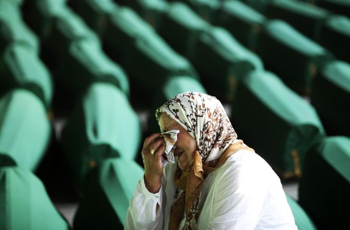 A Bosnian Muslim woman cries near coffins prepared for a mass burial at the Memorial Center in Potocari, near Srebrenica July 9, 2012. The bodies of 520 recently identified victims of the Srebrenica massacre will be buried on July 11, the anniversary of the massacre when Bosnian Serb forces commanded by Ratko Mladic slaughtered 8,000 Muslim men and boys and buried them in mass graves, in Europe's worst massacre since World War Two. REUTERS/Dado Ruvic (BOSNIA - Tags: POLITICS ANNIVERSARY CONFLICT) Published: Čec. 9, 2012, 5:50 odp.