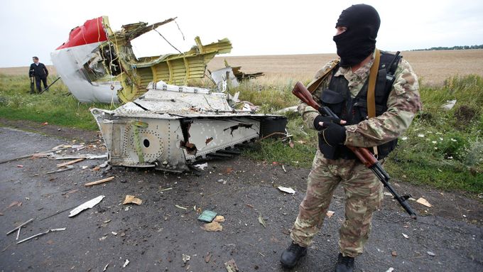 Proruský separatista stojí u kusu vraku boeingu, který byl sestřelen 17. července 2014 nad Ukrajinou.