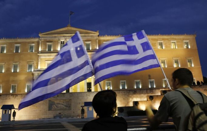 Protesters hold Greek flags in front of the Greek parliament during a demonstration against the upcoming visit by German Chancellor Angela Merkel in Athens October 8, 2012. About 6,000 policemen will be deployed in the capital for her six hour visit, turning the city centre into a no-go zone for protest marches planned by labour unions and opposition parties. REUTERS/Yannis Behrakis (GREECE - Tags: CIVIL UNREST POLITICS) Published: Říj. 8, 2012, 4:55 odp.