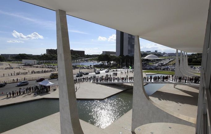 People line up in front of Planalto Palace to attend the funeral of Oscar Niemeyer in Brasilia December 6, 2012. Niemeyer, a towering patriarch of modern architecture who shaped the look of modern Brazil and whose inventive, curved designs left their mark on cities worldwide, died late on Wednesday. He was 104. Niemeyer had been battling kidney and stomach ailments in a Rio de Janeiro hospital since early November. His death was the result of a lung infection developed this week, the hospital said, little more than a week before he would have turned . REUTERS/Paulo Whitaker (BRAZIL - Tags: SOCIETY OBITUARY) Published: Pro. 6, 2012, 8:29 odp.