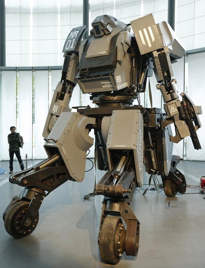 A man looks at a giant "Kuratas" robot at an exhibition in Tokyo November 28, 2012. The four-meter-high, limited edition, made-to-order robot is controlled through a pilot in its cockpit, or via a smartphone. The four-tonne (4,000 kg) "Kuratas" can be customised in 16 different colours, and is armed with a futuristic weapons system, including a multi-rocket launcher that fires plastic rockets filled with compressed water. REUTERS/Kim Kyung-Hoon (JAPAN - Tags: SOCIETY SCIENCE TECHNOLOGY) Published: Lis. 28, 2012, 4:16 dop.