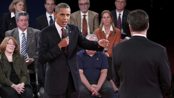 Prezident Obama gestikuluje směrem k Mittu Romneymu v jedné z ostrých výměn ve druhé prezidentské debatě. Za zády jsou nerozhodnutí voliči, kteří v debatě kladli otázky