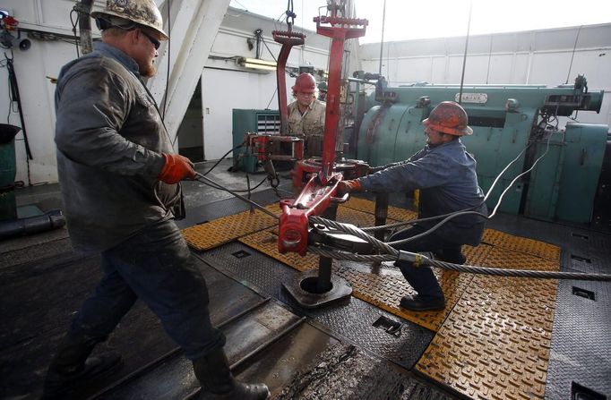 Roughnecks wrestle pipe on a True Company oil drilling rig outside Watford, North Dakota, October 20, 2012. Thousands of people have flooded into North Dakota to work in state's oil drilling boom. Picture taken October 20, 2012. REUTERS/Jim Urquhart (UNITED STATES - Tags: ENERGY BUSINESS EMPLOYMENT) Published: Říj. 22, 2012, 1:40 odp.