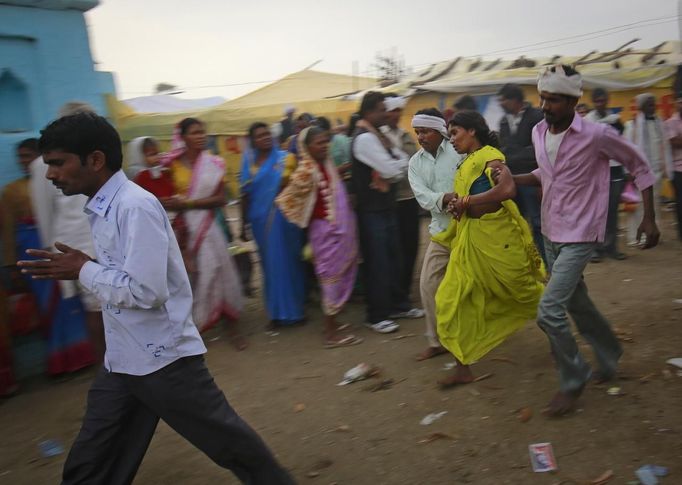 Relatives (R) of a devotee who is believed to be possessed by evil spirits hold her as she runs in a state of trance around the courtyard of Guru Deoji Maharaj temple during a ghost fair at Malajpur village in Betul district in the central Indian state of Madhya Pradesh January 27, 2013. People from across India come to this fair to be exorcised of �evil spirits�. They are usually brought by relatives and they are most often women. The exorcism involves running around the temple courtyard to make the 'ghost' weak then being beaten by a priest with a broom. Picture taken January 27, 2013. REUTERS/Danish Siddiqui (INDIA - Tags: SOCIETY RELIGION) ATTENTION EDITORS: PICTURE 8 OF 24 FOR PACKAGE 'INDIAN GHOSTBUSTERS' SEARCH 'INDIA GHOST' FOR ALL IMAGES Published: Úno. 5, 2013, 5:09 dop.