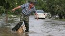 A local resident and a dog cross a flooded street in the town of Krymsk in Krasnodar region, southern Russia, July 8, 2012. Russian President Vladimir Putin ordered investigators to find out if enough was done to prevent 144 people being killed in floods in southern Russia after flying to the region to deal with the first big disaster of his new presidency. REUTERS/Eduard Korniyenko (RUSSIA - Tags: DISASTER ENVIRONMENT POLITICS ANIMALS) Published: Čec. 8, 2012, 8:06 dop.