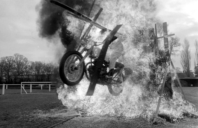 Eddie Merton projíždí na motorce hořící konstrukcí během nebezpečného kaskadérského vystoupení. Fotografie pochází z roku 1971.