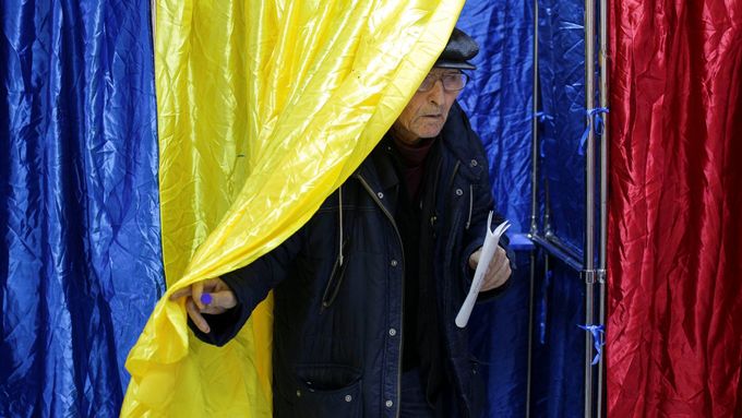 Muž opouští volební místnost v Bukurešti během parlamentních voleb.