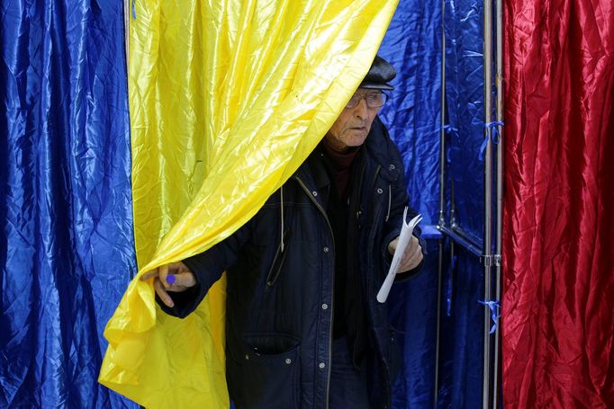 Muž opouští volební místnost v Bukurešti během parlamentních voleb.