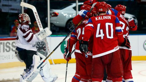 Russia's Sergei Kalinin (R) celebrates his goal against Latvia's goalie Kristers Gudlevskis (L) with team mates during the second period of their men's ice hockey World C
