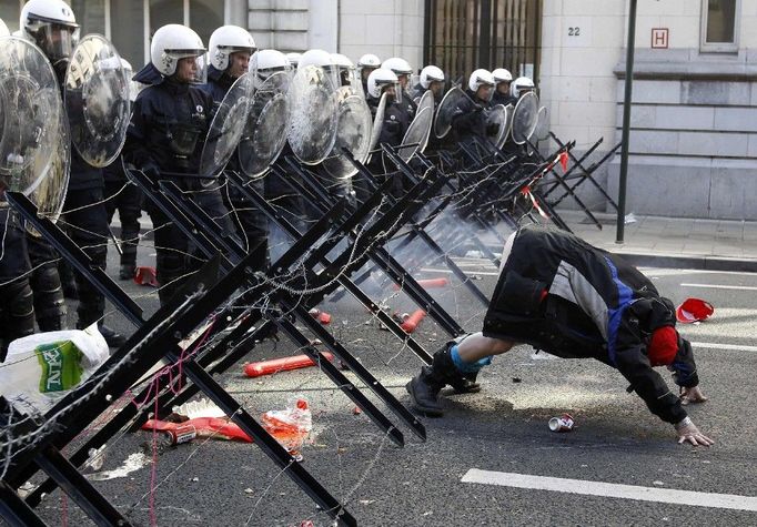 Jeden z demonstrantů ukazuje policistům své pozadí během demonstrace, která se uskutečnila 24. dubna v Bruselu. Protestujících, kterým se nelíbí úsporná opatření evropských vlád, se v belgické metropoli sešlo několik tisícovek. Demonstrace začala už v ranních hodinách na pěti různých místech a protestující se postupně vydali k budově Rady EU, kde se v pozdních odpoledních hodinách sešli lídři členských států včetně českého premiéra Petra Nečase.