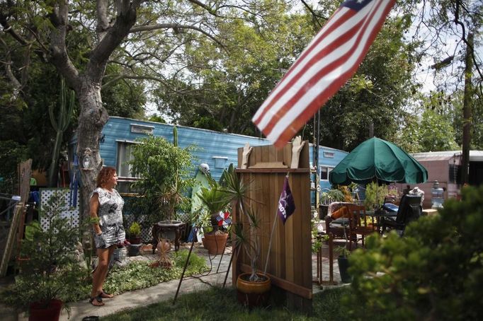 Dora Viesca, 52, stands outside her trailer in which she has lived for 21 years in Village Trailer Park in Santa Monica, California, July 13, 2012. Developer Marc Luzzatto wants to relocate residents from the trailer park to make way for nearly 500 residences, office space, stores, cafes and yoga studios, close to where a light rail line is being built to connect downtown Los Angeles to the ocean. Village Trailer Park was built in 1951, and 90 percent of its residents are elderly, disabled or both, according to the Legal Aid Society. Many have lived there for decades in old trailers which they bought. The property is valued at as much as $30 million, according the LA Times. REUTERS/Lucy Nicholson (UNITED STATES - Tags: REAL ESTATE BUSINESS SOCIETY POLITICS) Published: Čec. 14, 2012, 7:59 dop.